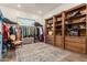 Walk-in closet with built-in wooden shelves, cabinets, clothing racks, and a decorative rug at 19912 E Natalie Way, Queen Creek, AZ 85142