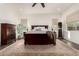 Spacious main bedroom features a ceiling fan, a large bed with a patterned rug and a window at 19912 E Natalie Way, Queen Creek, AZ 85142