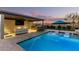 Outdoor oasis featuring a sparkling pool, swim-up loungers, and a covered patio with a built-in grill and bar, perfect for entertaining at 19912 E Natalie Way, Queen Creek, AZ 85142