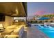 Enjoy outdoor living with an outdoor kitchen, seating, and bar, all adjacent to a sparkling pool featuring fountains and comfortable loungers at 19912 E Natalie Way, Queen Creek, AZ 85142