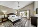 Serene main bedroom featuring a king bed, ceiling fan, ample natural light, and stylish decor at 19929 N 91St Ln, Peoria, AZ 85382