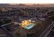 Stunning aerial view of property featuring a pool, backyard fire pit, lush landscaping and a mountain backdrop at 21442 E Excelsior Ave, Queen Creek, AZ 85142