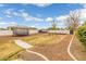 A backyard featuring a trampoline and landscaping including trees, ground cover and stone hardscape at 21442 E Excelsior Ave, Queen Creek, AZ 85142