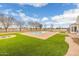 Beautiful backyard with a swimming pool, a fire pit, and landscaped lawn at 21442 E Excelsior Ave, Queen Creek, AZ 85142