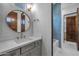 Stylish bathroom featuring round mirror, blue tiled shower, and modern finishes at 21442 E Excelsior Ave, Queen Creek, AZ 85142