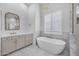 Bright bathroom featuring a soaking tub, modern fixtures, and marble flooring at 21442 E Excelsior Ave, Queen Creek, AZ 85142