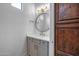 Charming powder room featuring stylish vanity with gold hardware and a wooden door at 21442 E Excelsior Ave, Queen Creek, AZ 85142