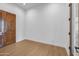 View of bedroom with wood flooring and dark wooden door at 21442 E Excelsior Ave, Queen Creek, AZ 85142