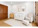 Cozy Bedroom space with rocking chair, white crib, and adorable animal artwork at 21442 E Excelsior Ave, Queen Creek, AZ 85142