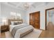 Bright bedroom featuring tray ceilings, wood closet, and light hardwood flooring at 21442 E Excelsior Ave, Queen Creek, AZ 85142
