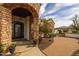 Close-up of the home's elegant stone archway, decorative iron door, and meticulously maintained landscaping at 21442 E Excelsior Ave, Queen Creek, AZ 85142