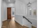 Bright hallway with hardwood floors, a wood sliding door, and a staircase at 21442 E Excelsior Ave, Queen Creek, AZ 85142