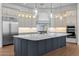 A modern kitchen features a large island with quartz countertops, stainless steel appliances, and custom cabinets at 21442 E Excelsior Ave, Queen Creek, AZ 85142
