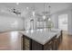 Bright kitchen with a large island featuring quartz countertops, stainless steel appliances, and modern lighting at 21442 E Excelsior Ave, Queen Creek, AZ 85142