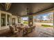 A covered outdoor seating area featuring a stone fireplace, ceiling fans, and view of the pool at 21442 E Excelsior Ave, Queen Creek, AZ 85142