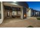 Outdoor covered patio with stone fireplace and furniture, as well as an arching roofline at 21442 E Excelsior Ave, Queen Creek, AZ 85142