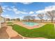 A backyard featuring a sparkling pool, well-manicured lawn, mature landscaping and brick hardscape at 21442 E Excelsior Ave, Queen Creek, AZ 85142