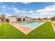 A backyard featuring a sparkling pool and a well-manicured lawn, complemented by a modern home design at 21442 E Excelsior Ave, Queen Creek, AZ 85142