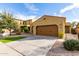 Tan home featuring desert landscaping, a two-car garage, and a well-manicured lawn at 227 E Carob Dr, Chandler, AZ 85286
