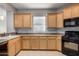 Bright kitchen featuring light wood cabinets, a window, and black appliances at 227 E Carob Dr, Chandler, AZ 85286
