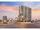 A tall apartment building is shown in a bustling downtown area with a colorful sunset sky at 2323 N Central Ave # 1902, Phoenix, AZ 85004