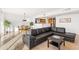 Bright living area with a large black sofa, tile flooring, and an open view to the dining area at 2323 N Central Ave # 1902, Phoenix, AZ 85004