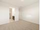 Spacious bedroom featuring carpeted floors, white walls, and a doorway leading to a walk-in closet and bathroom at 24369 W La Salle St, Buckeye, AZ 85326