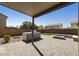 Backyard with a covered patio, built-in grill, fire pit, and hardscape at 3423 E Superior Rd, San Tan Valley, AZ 85143