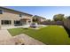 Spacious backyard featuring a built-in grill, fire pit, and lush green lawn at 3423 E Superior Rd, San Tan Valley, AZ 85143
