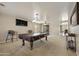 Spacious game room with a pool table, carpet flooring, and decorative lighting fixtures at 3423 E Superior Rd, San Tan Valley, AZ 85143
