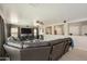A spacious living room featuring a large leather sectional, neutral walls, and lots of natural light at 3423 E Superior Rd, San Tan Valley, AZ 85143