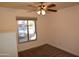 Bedroom with tan carpet, ceiling fan, and car view from the window at 3708 W Redfield Rd, Phoenix, AZ 85053