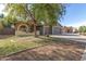 Inviting home exterior showcasing a well-maintained lawn, mature tree, and a three-car garage at 3765 E Del Rio St, Gilbert, AZ 85295