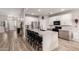 Modern kitchen with a large waterfall island, stainless steel appliances, white cabinets, and wood-look tile flooring at 3765 E Del Rio St, Gilbert, AZ 85295