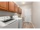 Functional laundry room featuring white washer and dryer, sink, cabinets, and door at 3765 E Del Rio St, Gilbert, AZ 85295