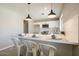 Bright kitchen with breakfast bar, white cabinets, stainless appliances and modern pendant lighting at 4026 W Saint John Rd, Glendale, AZ 85308