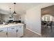 Modern kitchen open to dining and living areas, featuring white cabinets and stainless steel appliances at 4026 W Saint John Rd, Glendale, AZ 85308