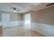 Bright living room with tile floors, wainscoting, and ceiling fan at 406 E Saguaro St, Casa Grande, AZ 85122