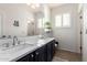 Elegant bathroom with double vanity, white marble counters and modern fixtures at 44560 W Copper Trl, Maricopa, AZ 85139