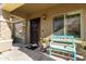 Cozy front porch with secure iron door, decorative potted plants, and a charming bench at 44560 W Copper Trl, Maricopa, AZ 85139
