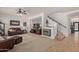 Inviting living room features a cozy fireplace, comfortable leather seating, and staircase at 44560 W Copper Trl, Maricopa, AZ 85139