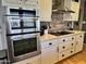 Modern kitchen featuring stainless steel appliances, stone backsplash and white cabinetry at 4626 S Kachina Dr, Tempe, AZ 85282