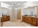 Primary bathroom with stone-look floor, double vanities, and a custom walk-in glass block shower at 6128 E Brilliant Sky Dr, Scottsdale, AZ 85266