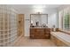 Stone floored bathroom with glass shower and tub with granite countertops at 6128 E Brilliant Sky Dr, Scottsdale, AZ 85266