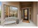Close up of home's entrance featuring bench seating, a decorative window, and dark wood door at 6128 E Brilliant Sky Dr, Scottsdale, AZ 85266