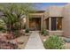 Exterior shot of home with desert landscaping, stone pathway, and covered entryway at 6128 E Brilliant Sky Dr, Scottsdale, AZ 85266