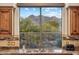 Kitchen sink with beautiful view of the nearby mountains and lush greenery at 6128 E Brilliant Sky Dr, Scottsdale, AZ 85266