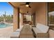 Covered outdoor patio with a dining table, fireplace, and adjacent pool with mountain views at 6128 E Brilliant Sky Dr, Scottsdale, AZ 85266