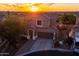 An aerial view of a two-story home showcasing its roof, landscaping, and surrounding neighborhood at sunset at 6230 S Mesa Vista Dr, Gold Canyon, AZ 85118