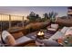 Inviting outdoor patio with a warm fire pit, cozy seating, and views of desert landscape at sunset at 6230 S Mesa Vista Dr, Gold Canyon, AZ 85118
